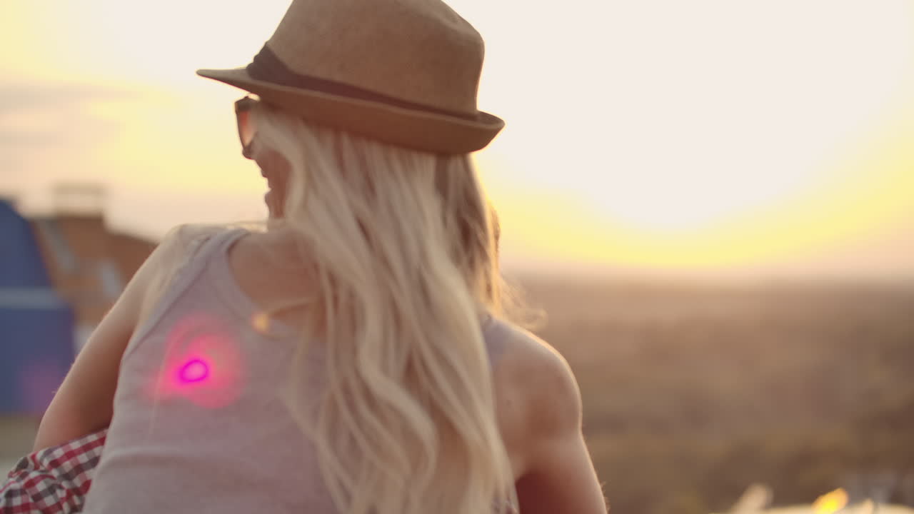 una pareja joven se mueve y gira en un baile. una chica sentada en la espalda de su novio.