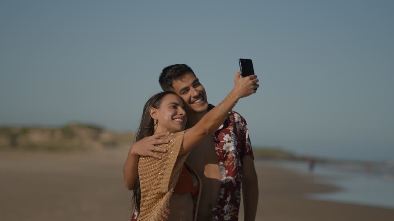 una pareja sonriendo en la playa.
