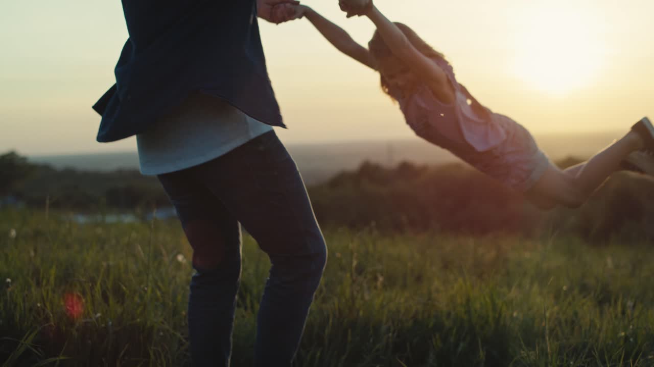 해가 지는 동안 잔디 ⁇ 에서 딸과 놀고 있는 아빠.
