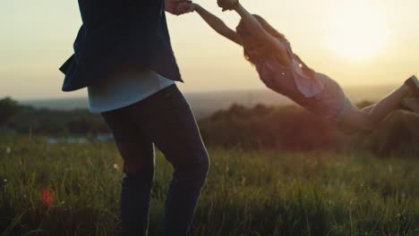 papá jugando con su hija en el prado durante la puesta de sol.