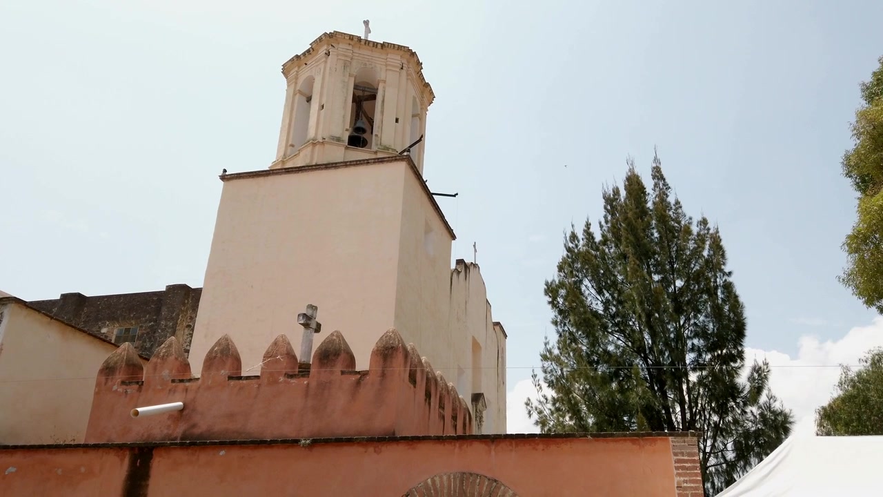 Storica torre campanaria con mura in pietra in stile coloniale e atmosfera da punto di riferimento religioso in una giornata di sole a Oaxaca, Messico.
