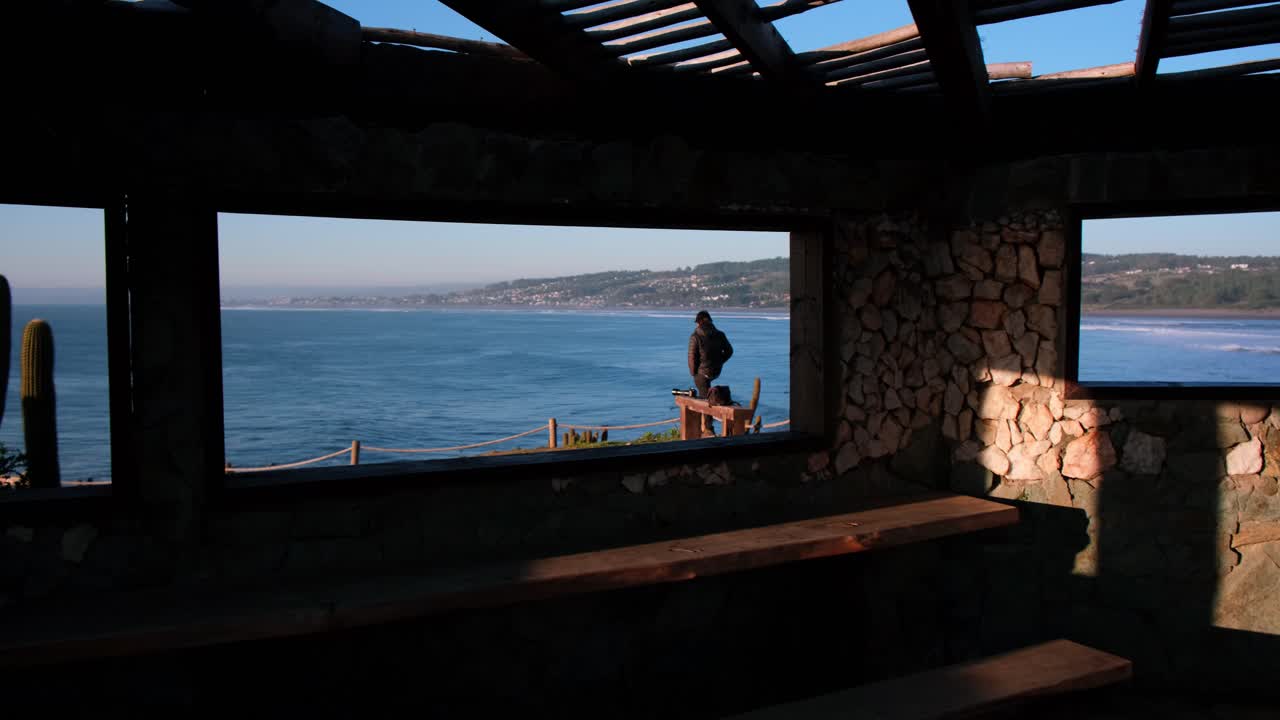 Person Contemplating the Ocean from a Cliffside Viewpoint