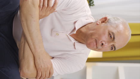 vertical video of worried and nervous old man at home watching outside.