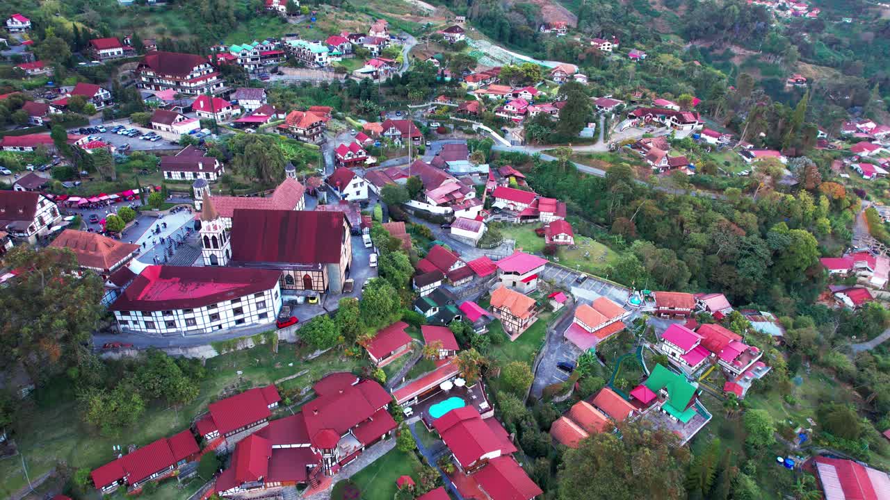 Splendida ripresa con drone della storica chiesa di San Martino di Tours e case con tetti rossi al tramonto nella foresta nebulosa venezuelana