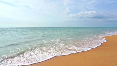 Empty-Pristine-Sandy-Beach-and-Turquoise-Sea-Waves-with-Endless-Skyline,-Static-Slow-Motion