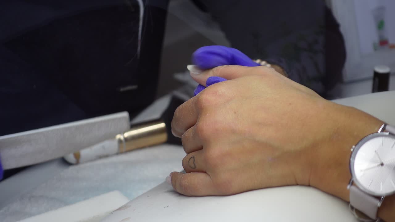 maestro haciendo manicura con lima de uñas película de primer plano