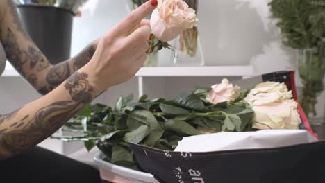 a florist stripping petals from a pink rose in slow motion