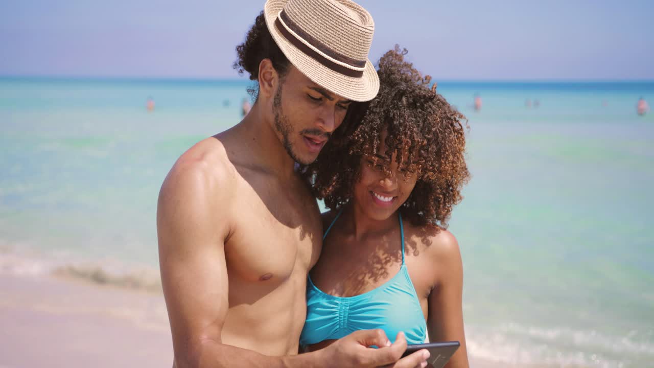 pareja tomando selfie en la playa