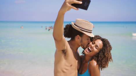Couple-taking-selfie-on-beach