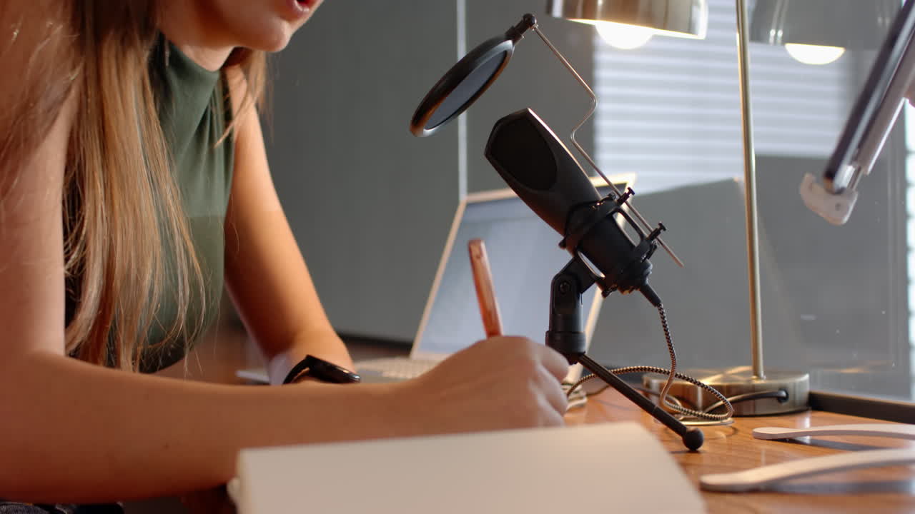 Recording audio, woman using microphone and laptop at home workspace