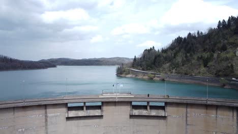 vuelo de aviones no tripulados sobre una presa hidroeléctrica y un lago de cristal | 4k