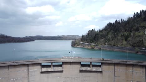 drone flight over a hydroelectric dam and a crystal lake | 4k