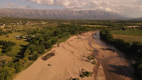 4k 60 fps landscape with sandy river with green shore and mountains at background at sunset