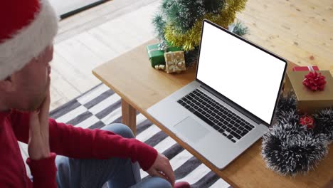 Caucasian-man-in-santa-hat-making-laptop-christmas-video-call,-copy-space-on-screen