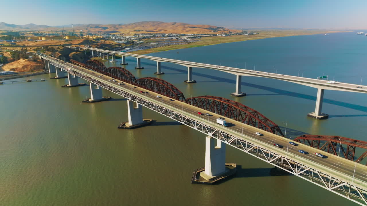 Bridges connecting Martinez to Benicia with transport moving by. Beautiful panorama of the strait and rocky landscape of Martinez, California on sunny daytime.