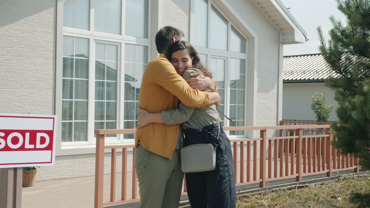 una pareja feliz recibiendo las llaves de la casa.