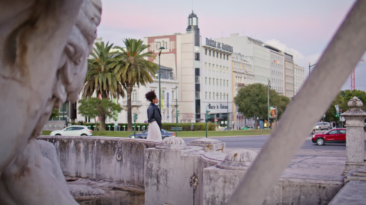 Contemplative woman standing fountain in urban cityscape. Stylish lady