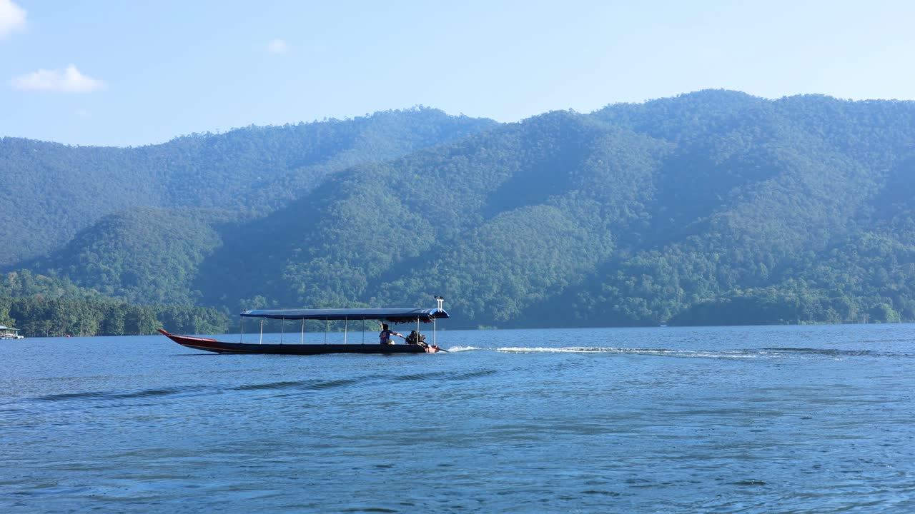 산 의 배경 으로 물 을 가로지르는 배