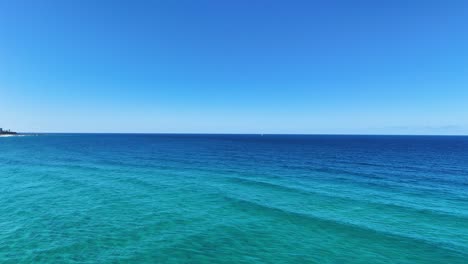 ocean waves and coastline under clear blue sky