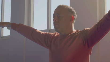 hombre haciendo ejercicios de tai chi con los ojos cerrados en el gimnasio
