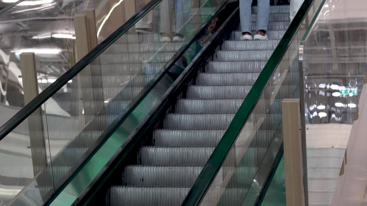 Folk kører op ad rulletrappen og snakker sammen