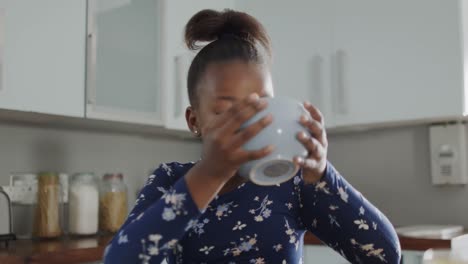 African-american-girl-sitting-at-countertop-and-eating-breakfast-in-kitchen,-slow-motion,-unaltered