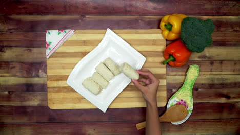 una vista superior de sacar el rollito de primavera no frito en la bandeja, dos grandes pimientos amarillos y rojos y un brócoli verde en la mesa