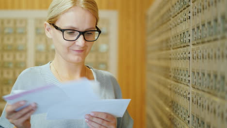 retrato de una mujer joven y elegante con un paquete de cartas en las manos en la oficina de correos