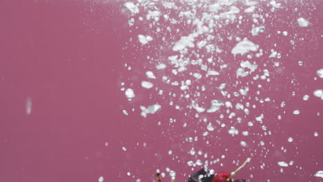 video de cerezas cayendo en el agua con espacio de copia en fondo rojo