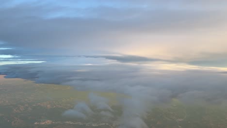 flying across a colorful sky with some fluffy clouds early in the moring near barcelona coast, spain