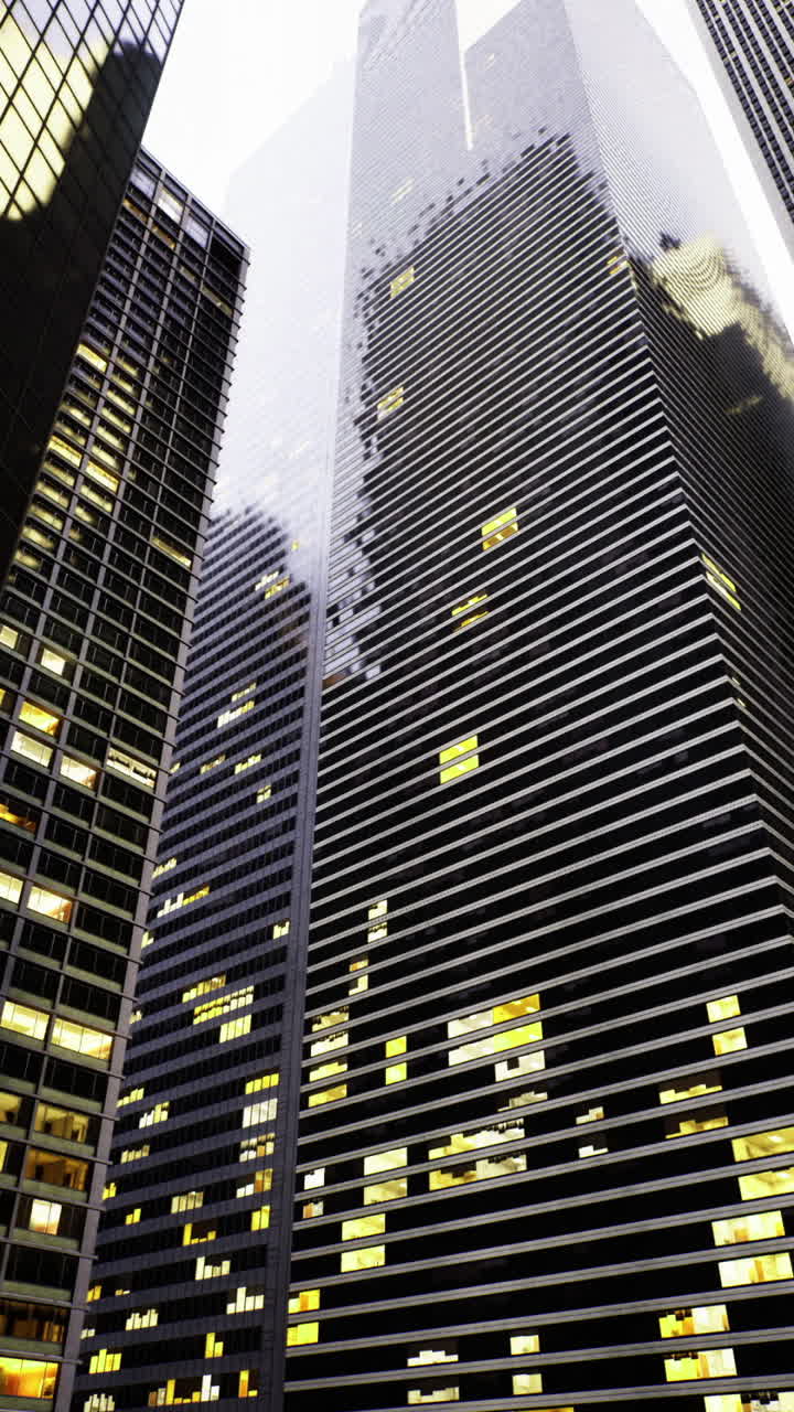 Skyward view of urban skyscrapers with illuminated windows in twilight