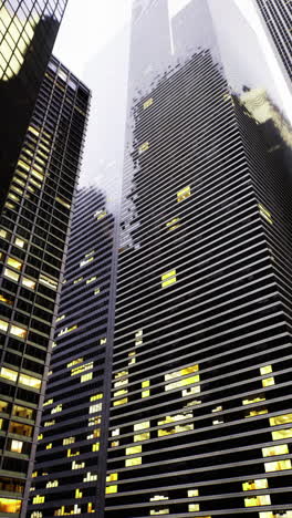 skyward view of urban skyscrapers with illuminated windows in twilight