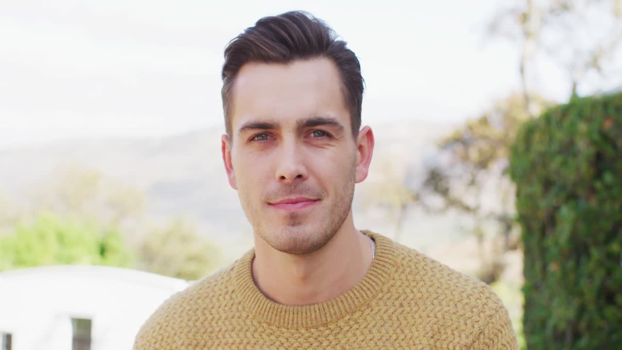 retrato de video de un hombre caucásico feliz con cabello corto sonriendo a la cámara en el jardín