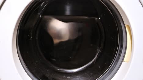 laundry spinning rapidly inside front-load washing machine during rinse phase
