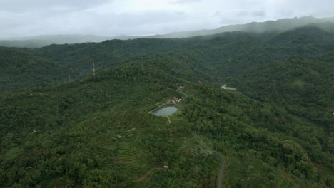 Vista-Aérea-Del-Bosque-Interminable-De-Colinas-Con-Estanque-De-Agua-Para-Depósito