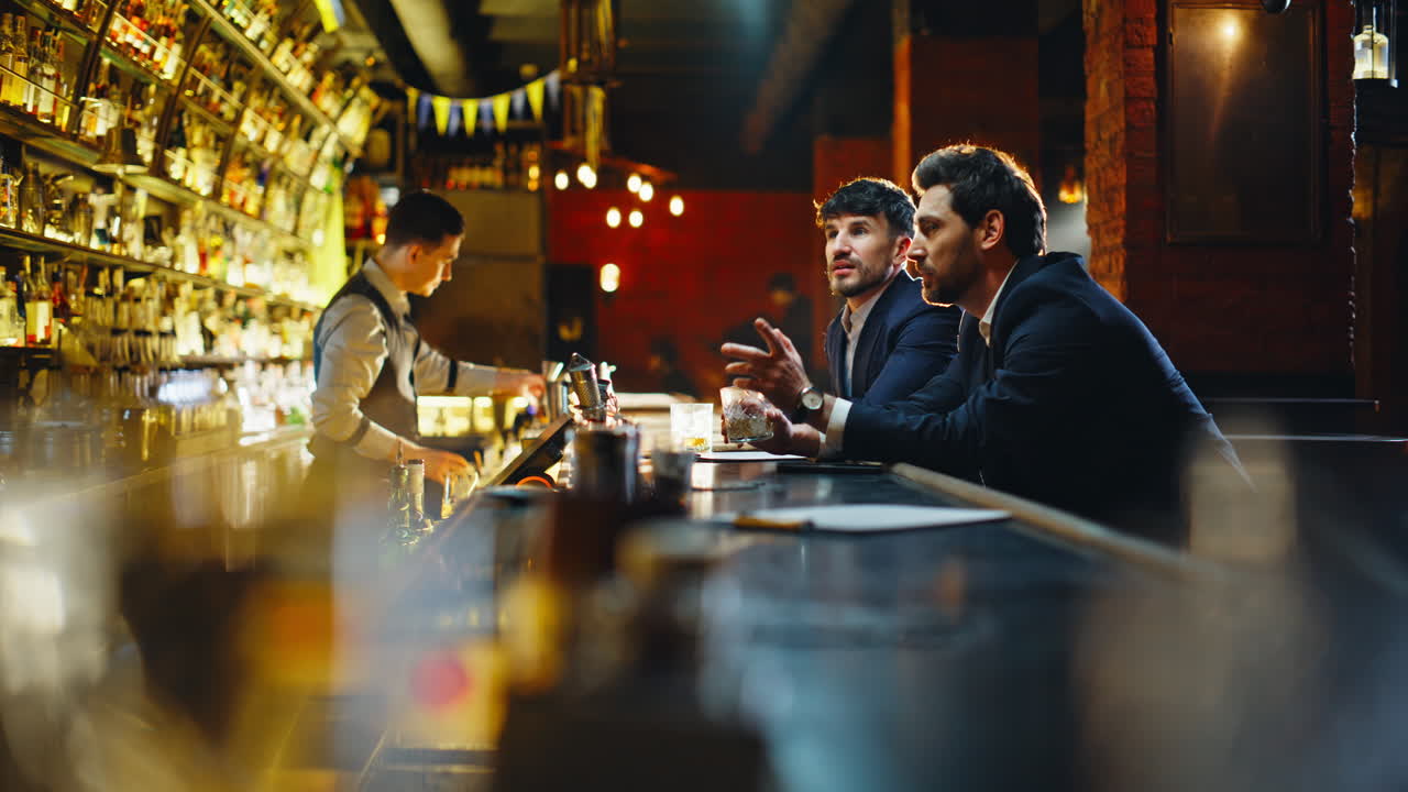 Primo piano di clienti di un bar che scelgono le bevande al bancone. Due amici che ordinano cocktail