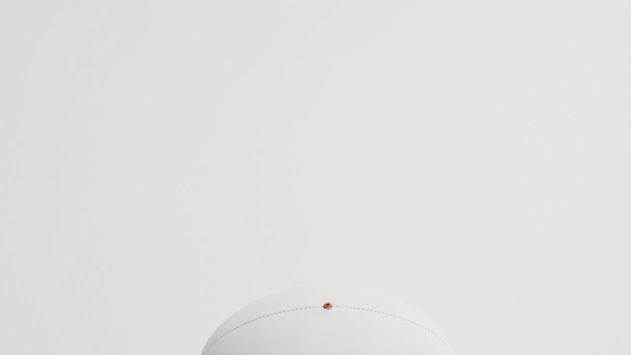 pelota de rugby blanca sobre fondo blanco con espacio de copia, cámara lenta