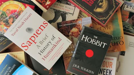 hand giving a thumbs up above a pile of best selling books