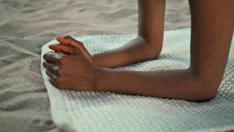 closeup girl hands yoga mat on sand seashore. unknown woman standing on elbows.