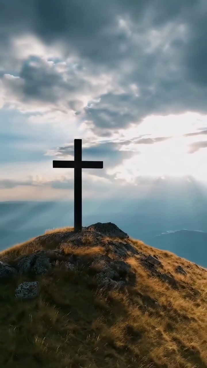 Cruz cristiana erigida en la cima de una montaña al atardecer