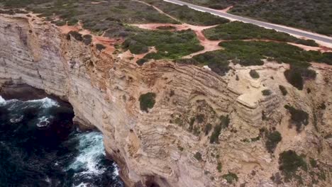 Volando-Sobre-Las-Hermosas-Olas-De-Espuma-Turquesa-Del-Magnífico-Océano-Y-Los-Impresionantes-Acantilados-De-Piedra-Caliza