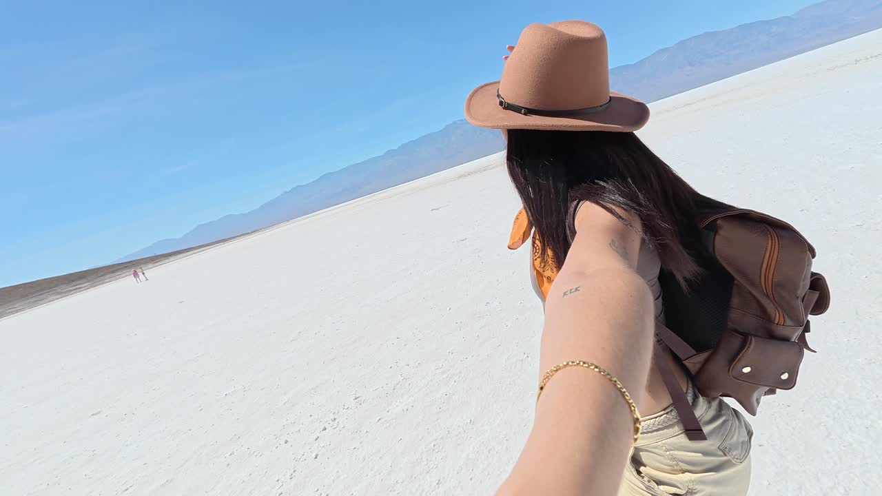 Donna felice che si scatta un selfie mentre cammina in un vasto deserto