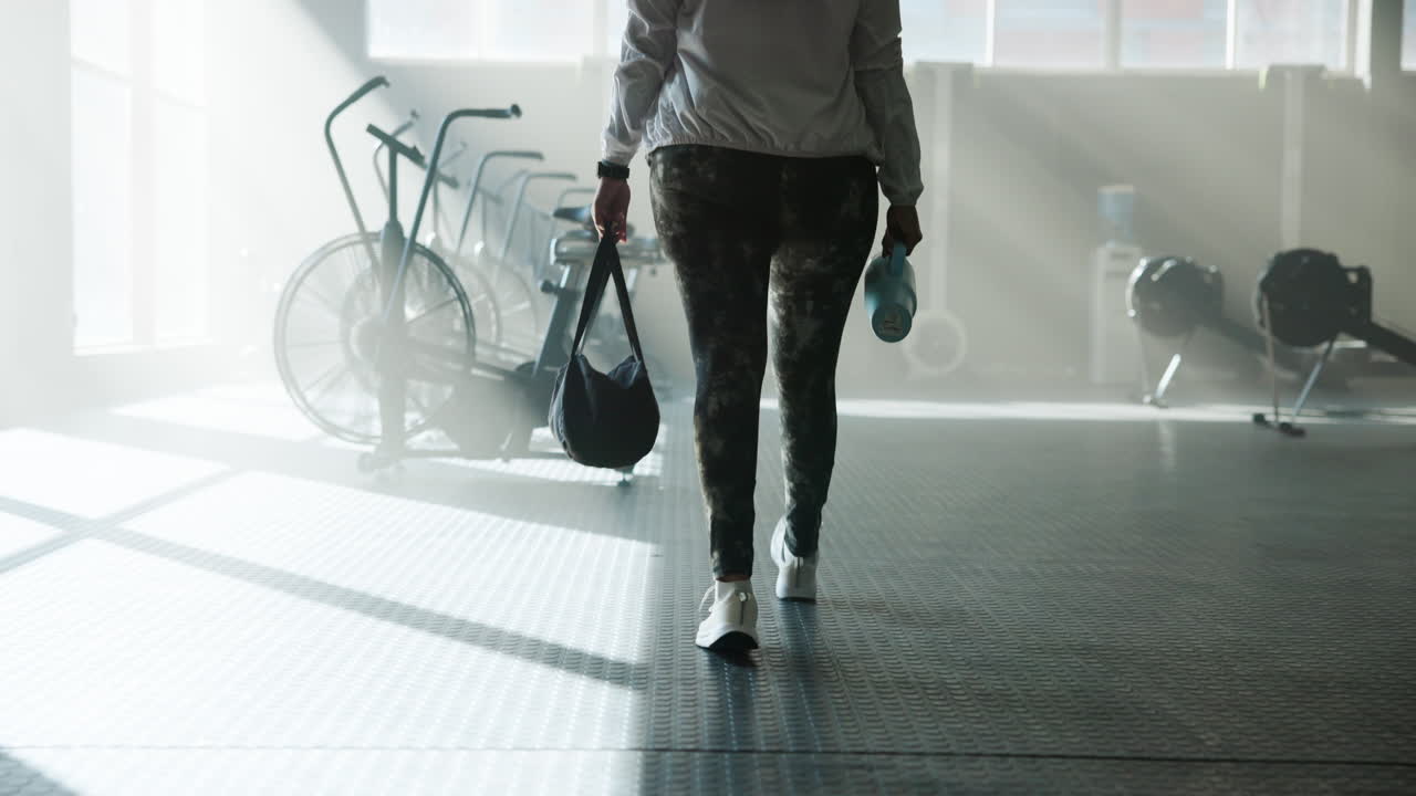Woman walking in gym with exercise equipment
