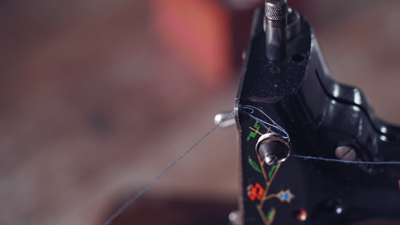 Old vintage hand sewing machine. Close up of woman put thread in needle