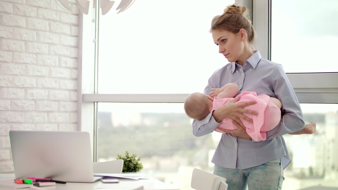 Maman tenant un bébé dans ses bras au bureau. Bébé endormi dans les bras de sa mère.