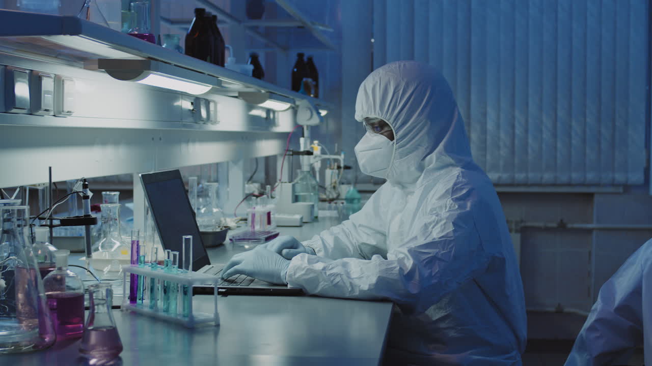 Forskere i engangsdragter udfører research i et laboratorium