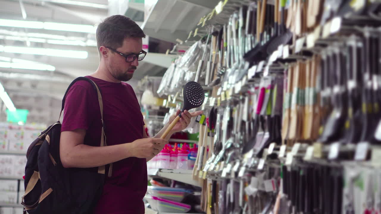 hombre comprando utensilios de cocina en un supermercado