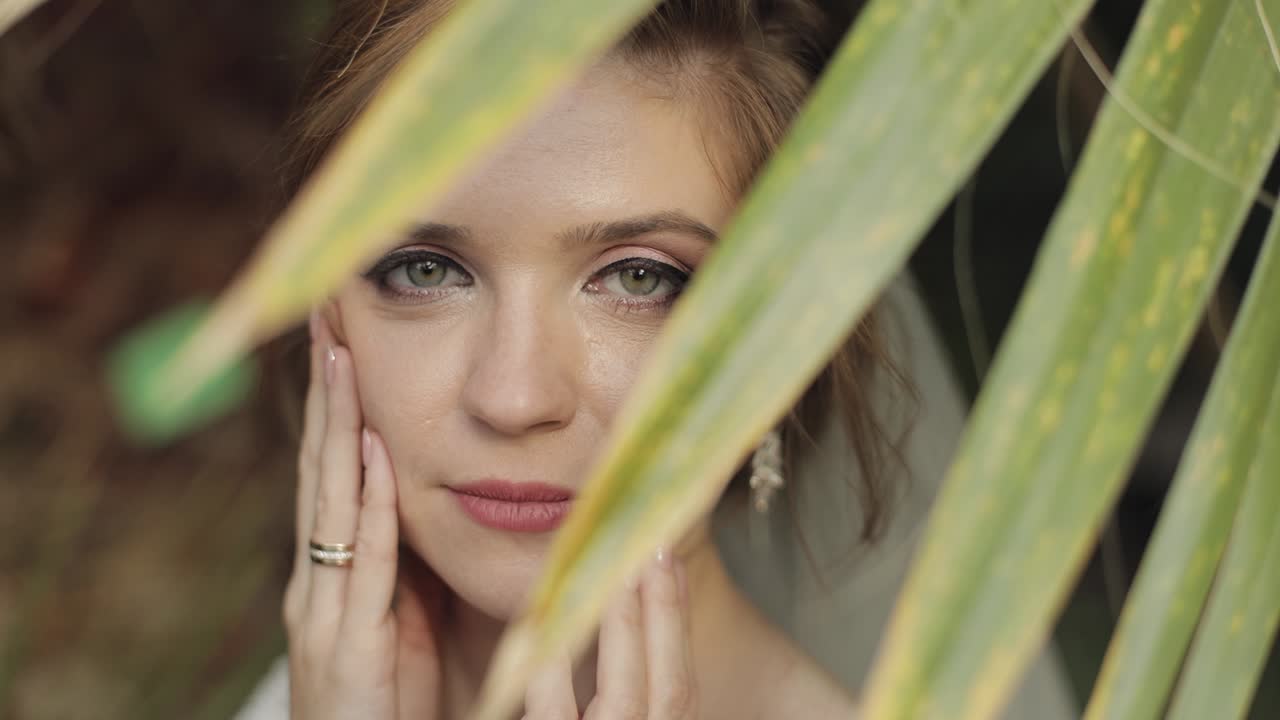 Bellissima sposa in posa in un giardino tropicale