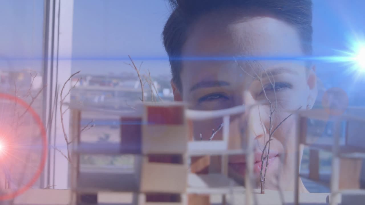 animación de luces azules y rojas brillando sobre la arquitecta que mira el modelo arquitectónico