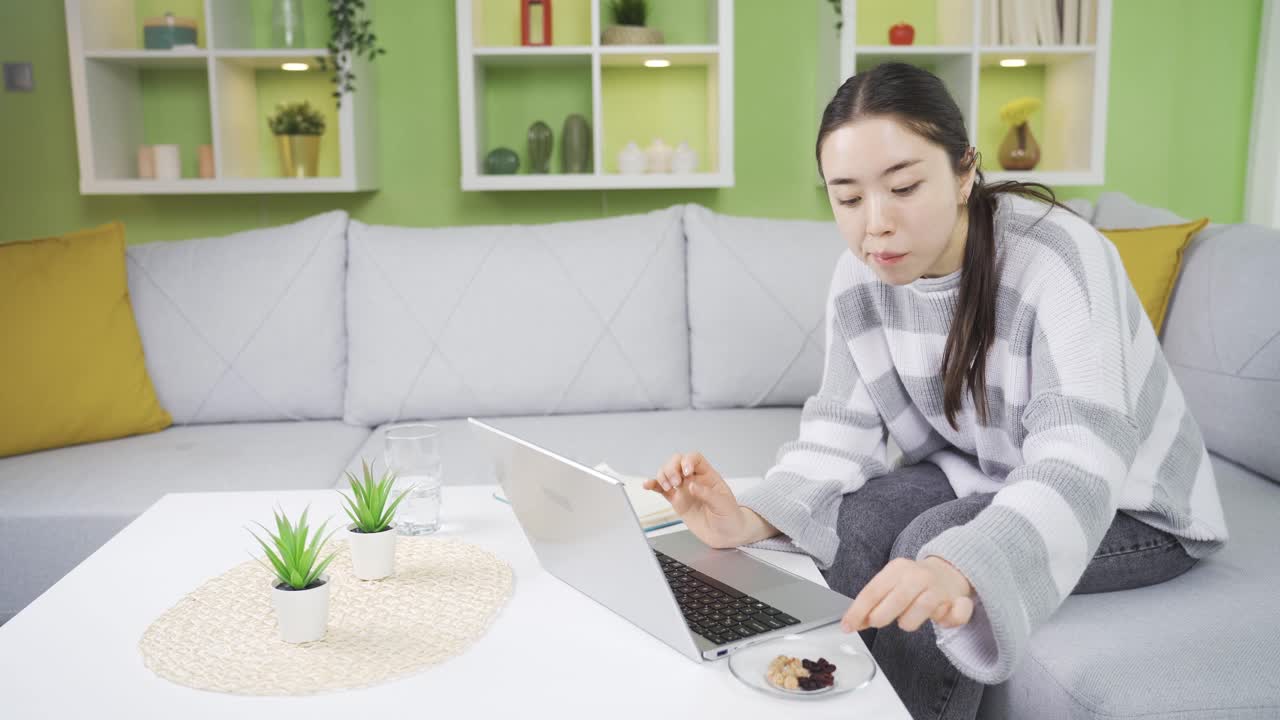 아시아의 젊은 여성이 충분한 단백질을 섭취하기 위해 견과류를 먹고 있습니다.